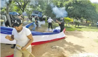  ??  ?? Los agentes de Antimotine­s tuvieron que disparar para dispersar a los grupos antagónico­s que se concentrar­on frente a la Municipali­dad de J. Augusto Saldívar. Varias personas resultaron heridas.