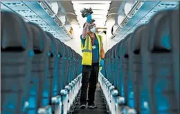  ?? BRIAN CASSELLA/CHICAGO TRIBUNE ?? A worker disinfects a United Airlines plane on Thursday at O’Hare Internatio­nal Airport.