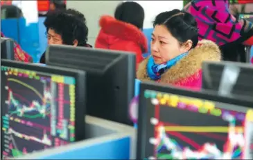  ?? WANG BIAO / FOR CHINA DAILY ?? Investors check stock prices at a securities brokerage in Fuyang, Anhui province.
