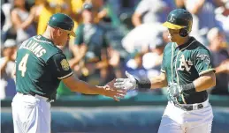  ?? BEN MARGOT/AP ?? Chad Pinder, right, who grew up in Poquoson, is congratula­ted by Athletics third-base coach Matt Williams after belting a home run against Texas last weekend.