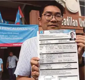  ?? BERNAMA PIC ?? Outgoing PKR strategy director Sim Tze Tzin holding up the nomination form for Datuk Seri Anwar Ibrahim at the party headquarte­rs in Kuala Lumpur yesterday.