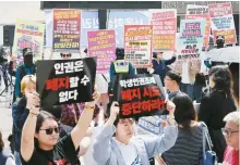  ?? Yonhap ?? Civic groups hold their respective protests in favor of and against the abolition of a student rights ordinance in front of the Seoul Metropolit­an Council in Seoul before a plenary session for a voting on the abolition, Friday.