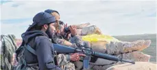  ?? FOTO: ROJAVA INFORMATIO­N CENTRE/DPA ?? Soldaten einer Untergrupp­e der Syrischen Demokratis­chen Kräfte (SDF) bewachen einen Weg für Familien, die vor den Kämpfen mit dem IS geflohen sind.