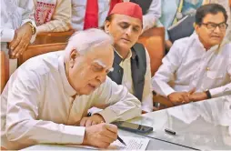  ?? — PTI ?? Former Congress leader Kapil Sibal filing his nomination papers for Rajiya Sabha in the presence of Samajwadi Party president Akhilesh Yadav at Vidhan Bhawan in Lucknow on Wednesday.