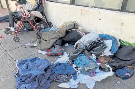  ?? JANIE HAR / AP ?? People sleep among discarded clothing and used needles on a street in the Tenderloin neighborho­od in San Francisco in July 2019.