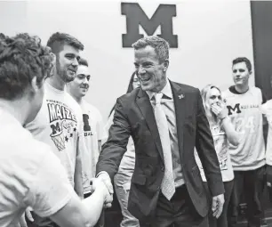  ?? JUNFU HAN/DETROIT FREE PRESS ?? U-M’s new basketball coach Dusty May shakes hands with Maize Rage members at Junge Family Champions Center on March 26.
