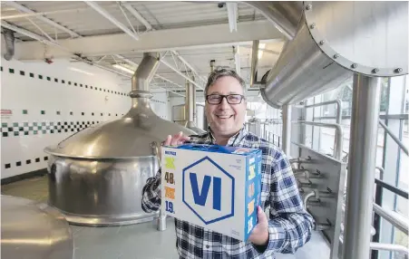  ??  ?? Vancouver Island Brewing president Tim Barnes with newly branded packaging and logo, at the brewry’s Government Street facility.