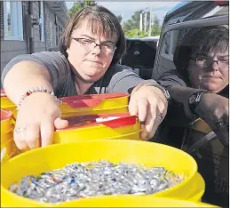  ?? ASHLEY THOMPSON ?? Angie Cress gets in close to scoop up thousands of pop can tabs that have been collected for a local fundraiser.