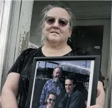  ?? STEVE BOSCH/VANCOUVER SUN ?? Elouise Lord holds a photo of herself with husband David and son Derik, whose attempts to get parole from his life sentence have failed.