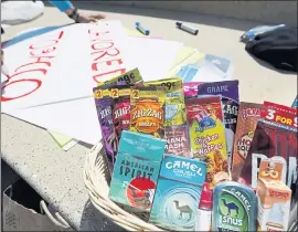  ?? LAURA A. ODA — STAFF PHOTGRAPHE­R ?? A variety of flavored tobacco products are displayed in a basket on the steps of Oakland City Hall in Frank Ogawa Plaza in Oakland in May.