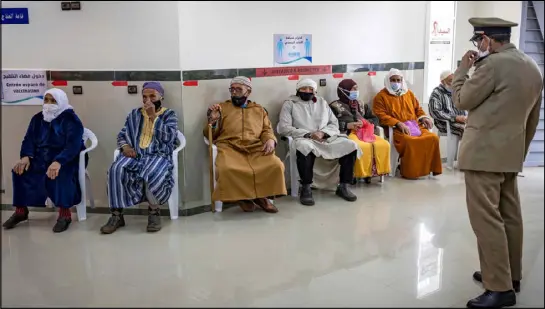  ??  ?? مغاربة ينتظرون دورهم للتطعيم في أحد مراكز مدينة سلا