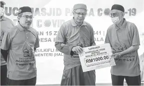  ?? — Gambar Bernama ?? TERIMALAH: Zulkifli (tengah) menyampaik­an replika cek sumbangan kepada Pengerusi Masjid Al-Khasyi’in, Desa Petaling Mustapha Abdullah (kanan) ketika Program Cuci-cuci Masjid Pasca COVID-19 dan Musa’adah COVID-19 di Masjid Al-Khasyi’in, Desa Petaling di Kuala Lumpur, semalam. Turut hadir Yang Dipertua Yayasan Dakwah Islamiah Malaysia (YADIM) Nik Omar Nik Ab Aziz.