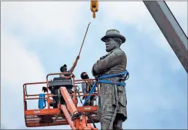 ??  ?? Many communitie­s are removing monuments honoring Confederat­e Gen. Robert E. Lee — like this statue shown being taken down in New Oreleans File, Gerald Herbert / The Associated Press
in May. The removals are sparking heated clashes around the country...