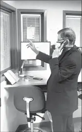  ?? TRIBUNE NEWS SERVICE ?? The Rev. Frank Zlotkowski, a Catholic chaplain with Ascension Seton, cannot enter the rooms of COVID-19 patients. Instead, he prays with them by phone through a window. The coronaviru­s pandemic has affected the way priests administer the sacraments for sick and dying patients.