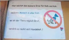  ?? FOTO: DPA ?? In Ernen im Schweizer Kanton Wallis weisen Bauern und Gemeinden mit Schildern Hundebesit­zer auf ihre Pflichten hin.