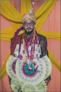  ??  ?? Saqib Fazili, a Kashmiri groom, poses for photograph during a wedding ceremony.