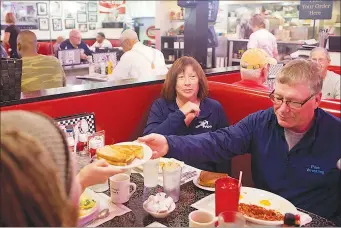  ?? ANDREW SPEAR / THE NEW YORK TIMES ?? Charlotte Ondrus, center, has breakfast with her family and a friend on Oct. 13 at Tommy’s Diner in Columbus, Ohio. Ondrus, a retired high school social studies teacher, hasn’t historical­ly voted Republican or Democrat but will vote for Hillary Clinton...