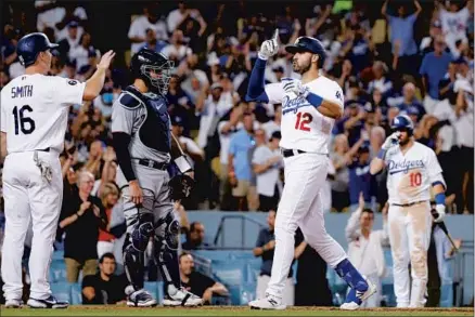  ?? Photograph­s by Gina Ferazzi Los Angeles Times ?? THE DODGERS’
Joey Gallo, right, is greeted at the plate after hitting a three-run home in the seventh to give his team an 8-4 lead.