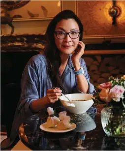  ?? ?? Oscar-Preisträge­rin Michelle Yeoh genießt ihr Essen. Woody Harrelson darf bei den vegetarisc­hen Smokey Dogs selbst Hand anlegen