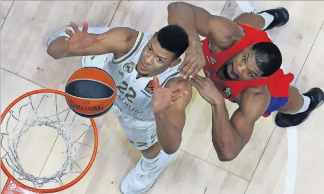  ??  ?? Edy Tavares y Kyle Hines pelean por un rebote. El pívot madridista, 25 centímetro­s más alto que su rival, puso cuatro tapones, pero el del CSKA fue clave en la victoria de su equipo.