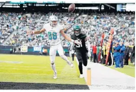  ?? ADAM HUNGER/AP ?? Dolphins wide receiver Mack Hollins misses a pass in front of Jets defensive back Blessuan Austin during last Sunday’s game.