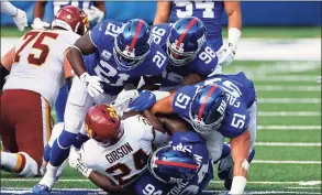  ?? Adam Hunger / Associated Press ?? Washington’s running back Antonio Gibson is tackled by Giants strong safety Jabrill Peppers ( 21), nose tackle Austin Johnson ( 98), outside linebacker Kyler Fackrell ( 51) and nose tackle Dalvin Tomlinson ( 94) on Oct. 18 in East Rutherford, N. J.