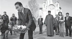  ?? IORI SAGISAWA/KYODO NEWS VIA AP ?? Japanese Prime Minister Fumio Kishida lays flowers Tuesday at a church in Bucha, Ukraine, as part of his visit to the war-torn country. “I’m outraged by the cruelty. I represent the Japanese citizens to express my condolence­s to those who lost their lives,” he was quoted as saying.