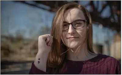  ??  ?? Kelsey Bell stands in January on the riverbank near the Clinton Presidenti­al Center in Little Rock, the former site of an annual walk for suicide awareness. During a struggle with mental health issues during her childhood, Bell attempted suicide. Her semicolon tattoo is a symbol of her recovery and of suicide prevention. She now volunteers with the Arkansas chapter of the American Foundation for Suicide Prevention. (Arkansas Democrat-Gazette/Yutao Chen)