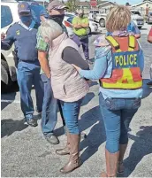  ??  ?? A 52-year-old woman aims a pistol after an altercatio­n with EFF anti-Clicks protesters at the Walmer Park shopping centre in Port Elizabeth on Tuesday. Local police responded to a complaint, and took the woman and two protesters briefly to the local police station.