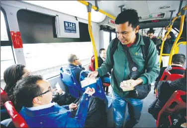  ?? AP/FERNANDO VERGARA ?? Venezuelan Jorge Gutierrez hawks a 100-bolivar bill to a passenger on a bus in Bogota, Colombia, in mid-December. Gutierrez says he can earn roughly $20 in a day selling the virtually worthless currency.