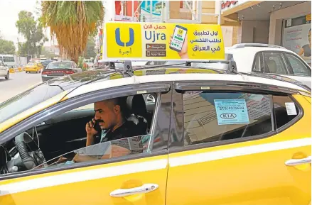  ?? KARIM KADIM/ASSOCIATED PRESS PHOTOS ?? Ali Raad, a taxi driver who works for the ride-hailing app Ujra, receives a call from a customer in Baghdad, Iraq. Techsavvy Iraqi entreprene­urs are finding success in creating companies that use apps inspired by foreign businesses.