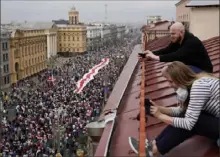  ?? Evgeniy Maloletka/Associated Press ?? Anti-government protesters carry a huge old Belarusian national flag as they march to Independen­ce Square in Minsk, Belarus, on Sunday.