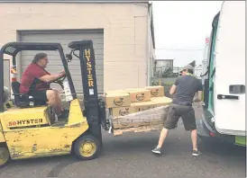  ?? SUBMITTED PHOTO ?? Lansdale Warehouse Company Transporta­tion Manager, Dean Mengel (left), and Maintenanc­e Assistant, Steve Wheeler (right), position to load Farmers to Families produce boxes on MontCo Anti-Hunger Network’s cargo van.