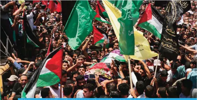  ?? —AFP ?? GAZA: Palestinia­n mourners carry the body of 21-years-old Razan Al-Najjar during her funeral after she was shot dead by Israeli soldiers in Khan Younis yesterday.