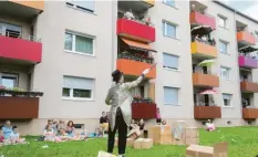  ?? Foto: Michael Hochgemuth ?? Vor den Balkonen einer Wohnanlage im Hochfeld traten die Künstler auf. Hier zeigt sich Christian Beppo Peters als verrückter Zauberer.