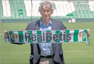  ??  ?? Manuel Pellegrini posa con una bufanda del Betis antes de ser presentado en el Villamarín.