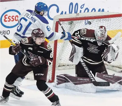  ?? CLIFFORD SKARSTEDT ?? Peterborou­gh Petes goalie Hunter Jones blocks a shot by Chase Stillman of the Sudbury Wolves in OHL action Feb. 17 at the Memorial Centre.
With the OHL delayed because of the pandemic, Stillman is playing in Denmark.