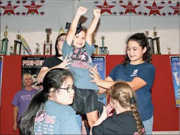  ?? Photos by John Bailey ?? ABOVE: Ava Lovering puts her hands way up as she is assisted by Brooke Dixon (behind), helper Isabel Morales, (bottom left) Kaelyn Childs and (bottom right) Chloe Sims. LEFT: Sarai Logan (Left) works through her routine with instructor Kalyn Brown at the Shining Stars practice. BELOW: (From left) Chloe Sims and Kaelyn Childs move through their routine.