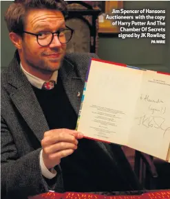  ?? PA WIRE ?? Jim Spencer of Hansons Auctioneer­s with the copy of Harry Potter And The Chamber Of Secrets signed by JK Rowling