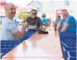  ?? FOTO: STEFANIE BÖCK ?? Vorbildlic­h am Vatertag (von links): Michael Sohler, Stefan Fink und Florian Kirchmann zwischen Abstandsbi­erkisten an der längsten Biertheke des Allgäus.