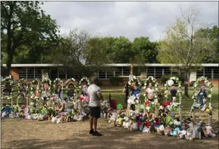  ?? PHOTOS BY THE ASSOCIATED PRESS ?? Brian Hackett, 39, visits a memorial at Robb Elementary School in Uvalde, Texas Monday, May 30, 2022, to pay his respects to the victims killed in last week’s school shooting.