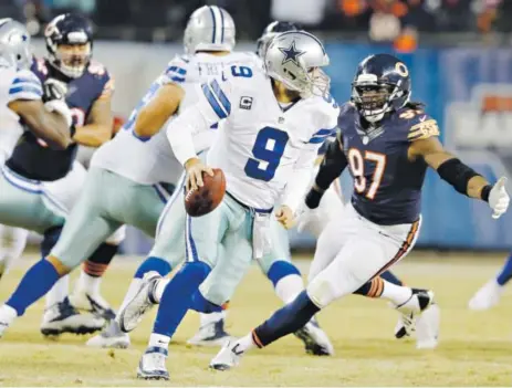  ??  ?? Dallas Cowboys quarterbac­k Tony Romo scrambles before throwing a touchdown pass to wide receiver Cole Beasley during the second half of Thursday night’s game against the Chicago Bears at Soldier Field. Nam Y. Huh, The Associated Press
