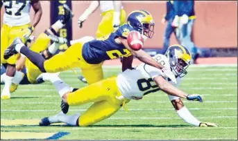  ??  ?? Michigan defensive back Jourdan Lewis, top, breaks up a pass intended for wide receiver Jehu Chesson, bottom, during
a spring NCAA college football game in Ann Arbor, Mich, on April 4. (AP).