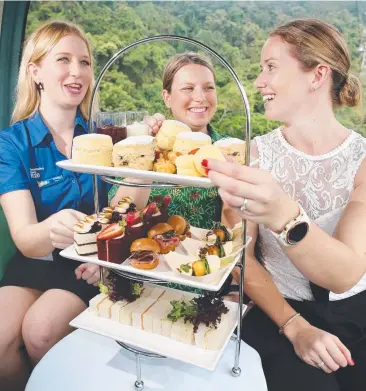  ?? Picture: BRENDAN RADKE ?? TASTY FARE: Cancer Council events co-ordinator Emma Wilson, Skyrail marketing officer Marni Cadd and Pullman Cairns business developmen­t manager Emma Tumbers enjoy a bite.