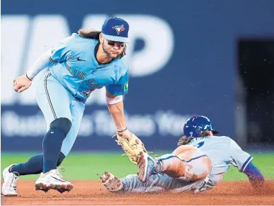  ?? VAUGHN RIDLEY GETTY IMAGES ?? Kansas City’s Bobby Witt Jr., right, is caught trying to steal second base by Bo Bichette in the sixth inning of Tuesday’s game at Rogers Centre. The Royals held on for a 4-1 victory over the Blue Jays.