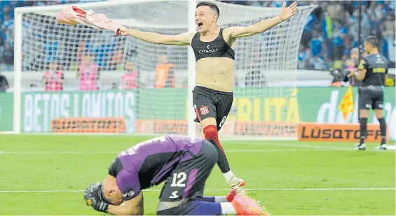  ?? EFE ?? Grito de campeón. Fernando Zuqui acaba de convertir el penal decisivo. Matías Mansilla, hincado, había atajado tres remates a Vélez.