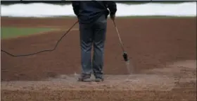  ?? MATT SLOCUM — ASSOCIATED PRESS ?? A grounds crew member heats the infield of Citizens Bank Park before Monday’s scheduled game between the Phillies and Washington Nationals in Philadelph­ia.