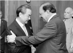  ??  ?? Hussain shakes hands with Yi upon his arrival at President House in Islamabad. — AFP photo