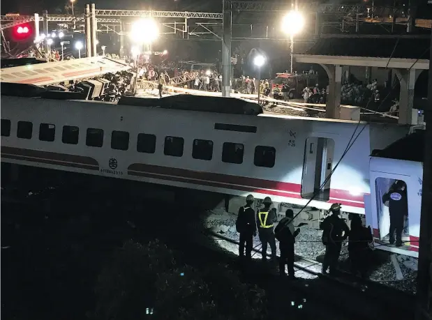  ?? JOHNSON LAI / THE ASSOCIATED PRESS ?? Rescue workers at a fatal train derailment in northern Taiwan on Sunday. There was no immediate word on the cause of the accident.