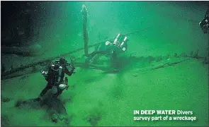  ??  ?? IN DEEP WATER Divers survey part of a wreckage